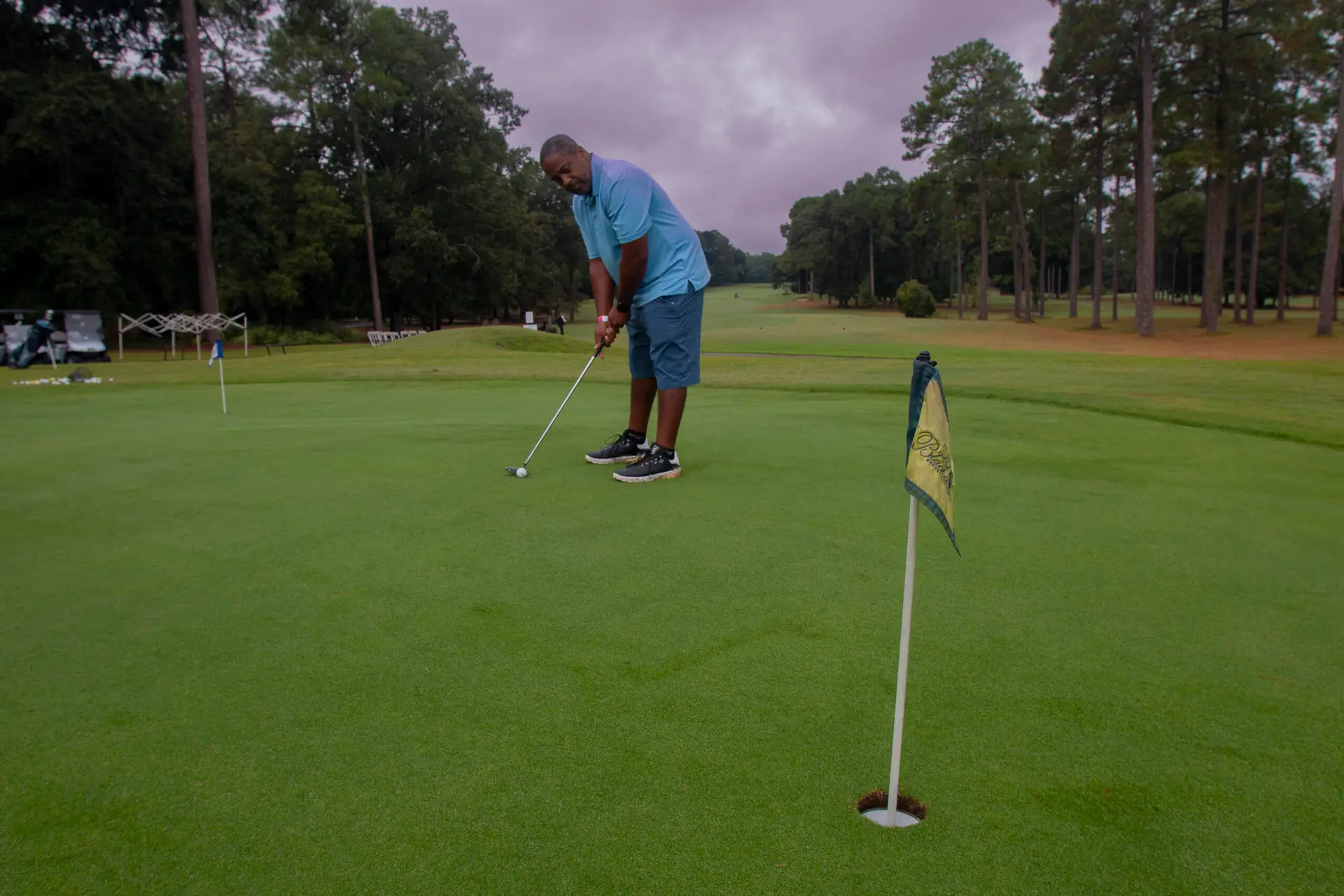 Cousin's Cup Golf Tournament @ Melanated Campout 7 A Camp Cousin putting toward the flag on an open green