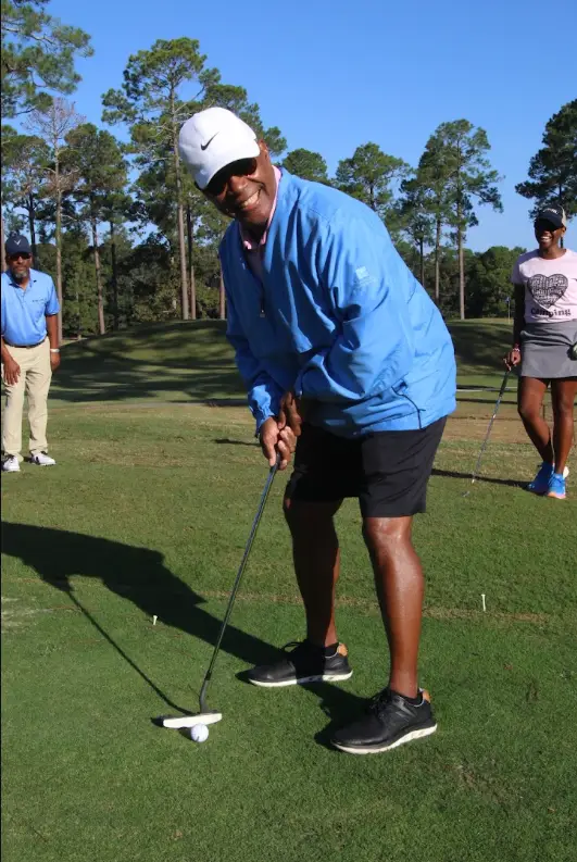 Cousin's Cup Golf Tournament @ Melanated Campout 4 A Camp Cousin smiling mid-swing on the tee box