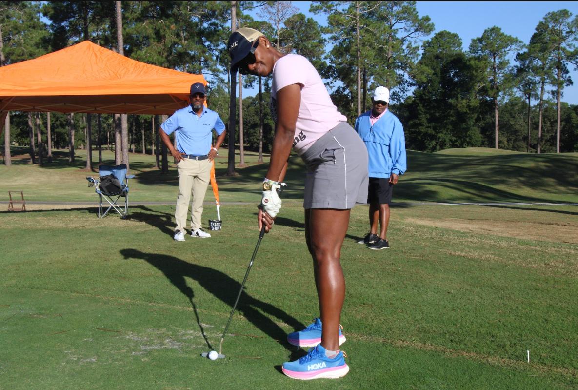 Cousin's Cup Golf Tournament @ Melanated Campout 9 A Camp Cousin driving from the practice range beside the orange tent