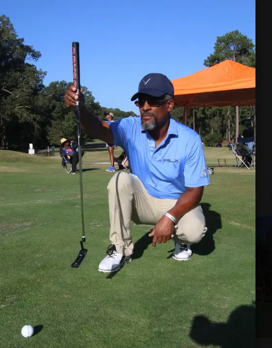 Cousin's Cup Golf Tournament @ Melanated Campout 6 A Camp Cousin kneeling on the green to read a putt
