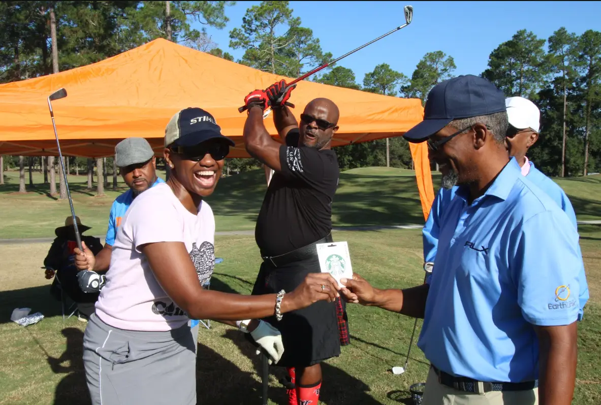 Cousin's Cup Golf Tournament @ Melanated Campout 8 Camp Cousins celebrating with a handshake near the practice tent