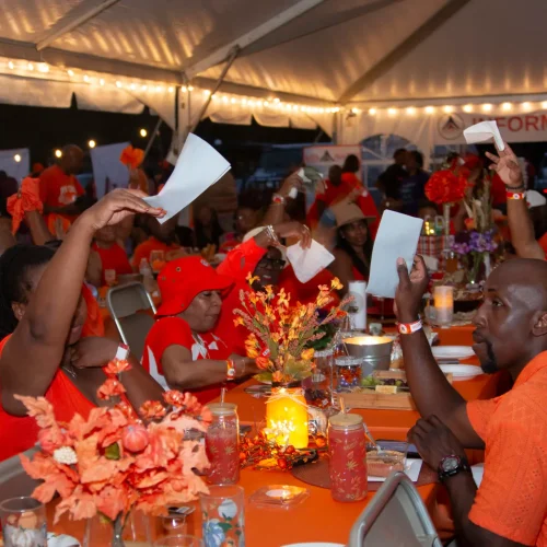 Homecoming 2026 9 Group dinner moment with orange napkin wave at Black camping event in Georgia